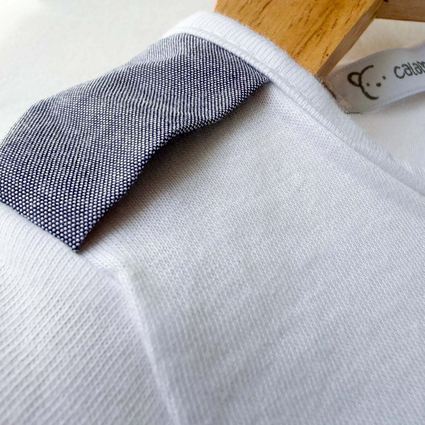 Detalle de conjunto de niño de camiseta con botones y pantalón corto de tela marino