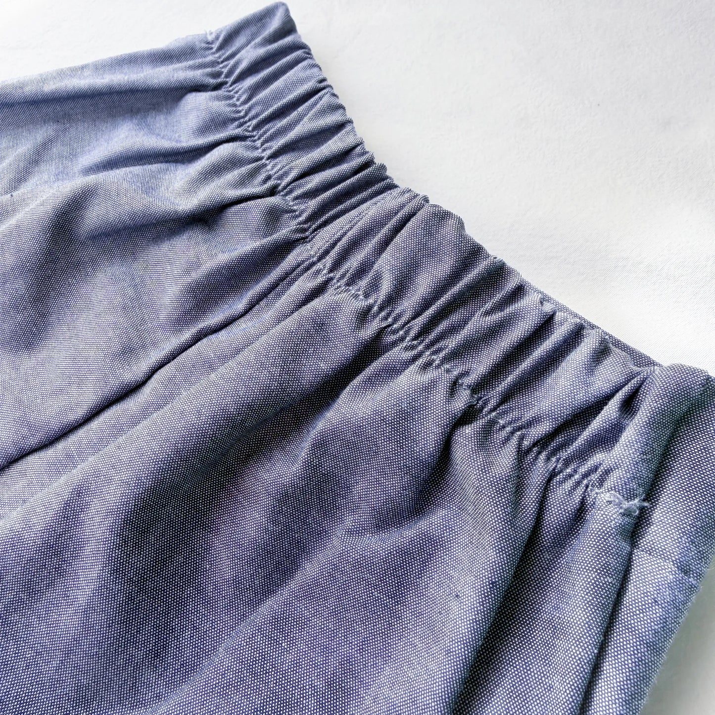 Detalle de conjunto de niño de camiseta con botones y pantalón corto de tela marino
