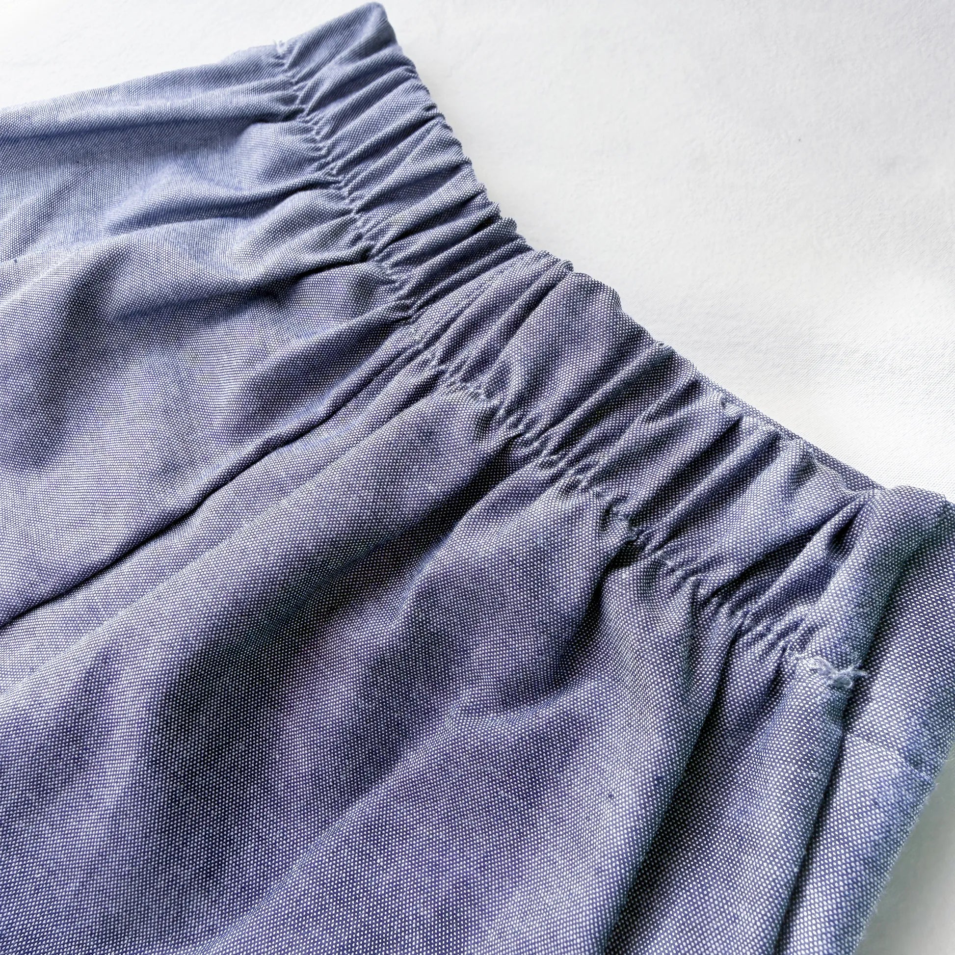 Detalle de conjunto de niño de camiseta con botones y pantalón corto de tela marino