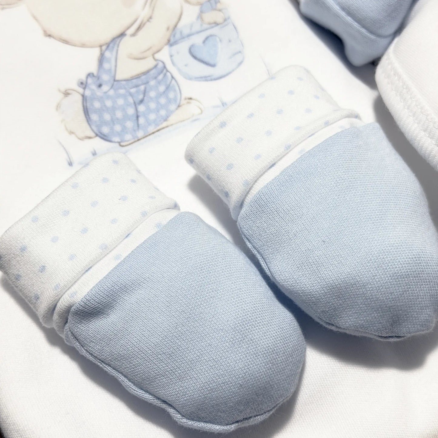 Detalle de conjunto de primera puesta con motivo de conejito en la cesta azul