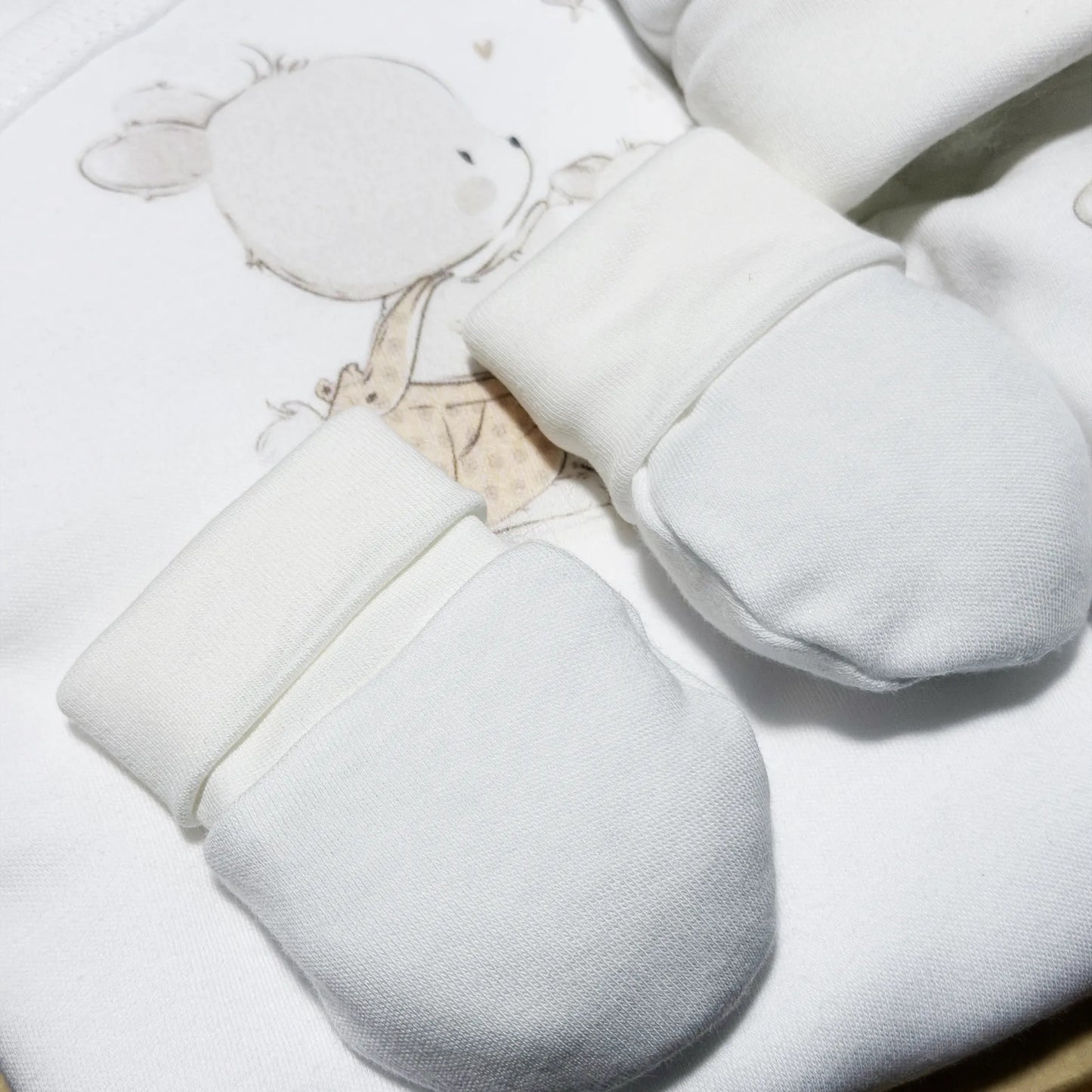 Detalle de conjunto de primera puesta con motivo de conejito en la cesta beige