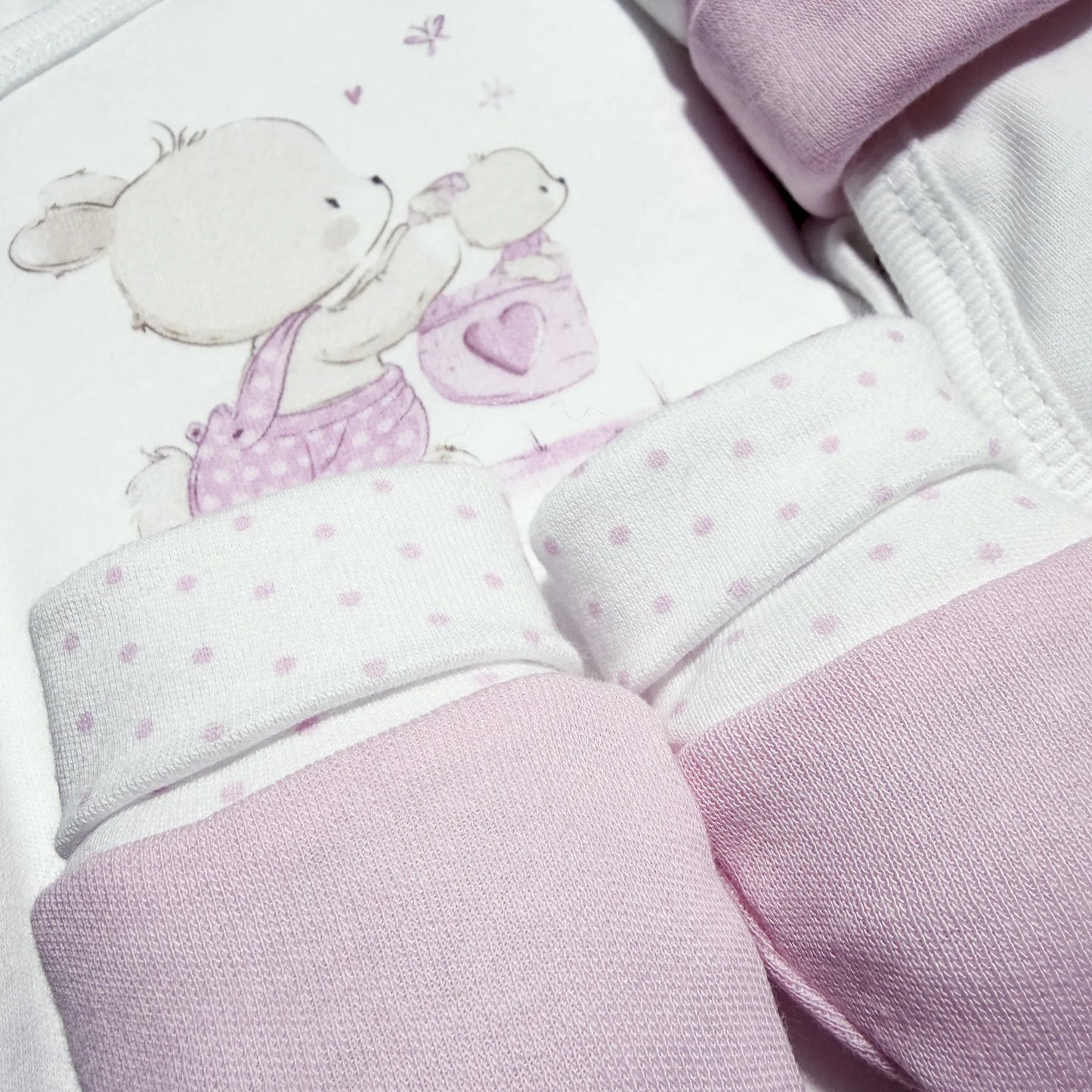 Detalle de conjunto de primera puesta con motivo de conejito en la cesta rosa