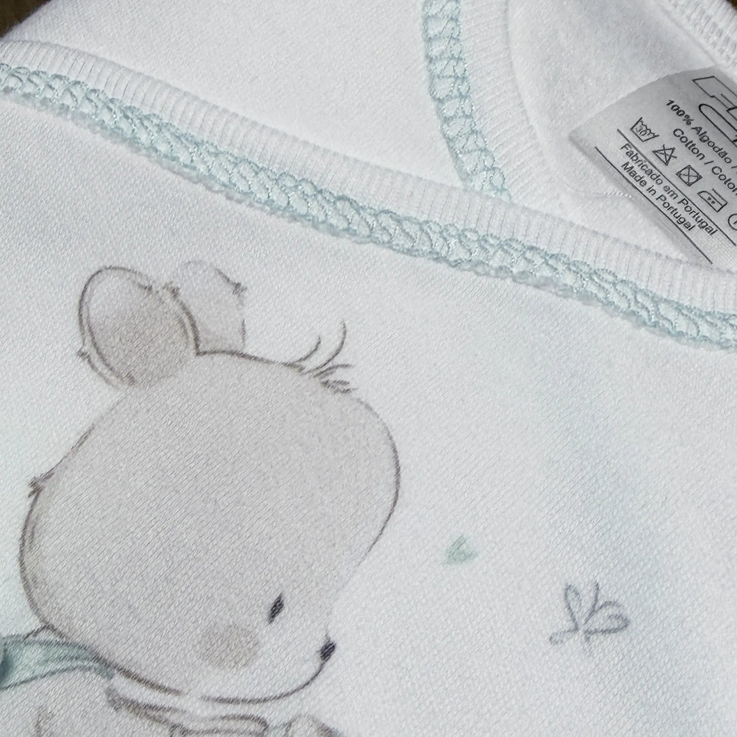 Detalle de conjunto de primera puesta con motivo de conejito en la cesta verde