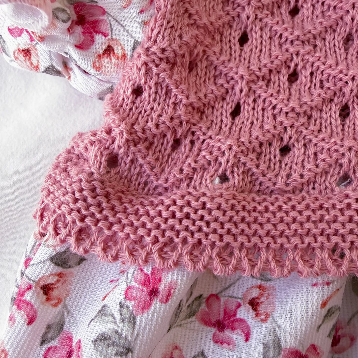 Detalle de ranita de niña de estampado floral con volante en el cuello y lazo en la frente