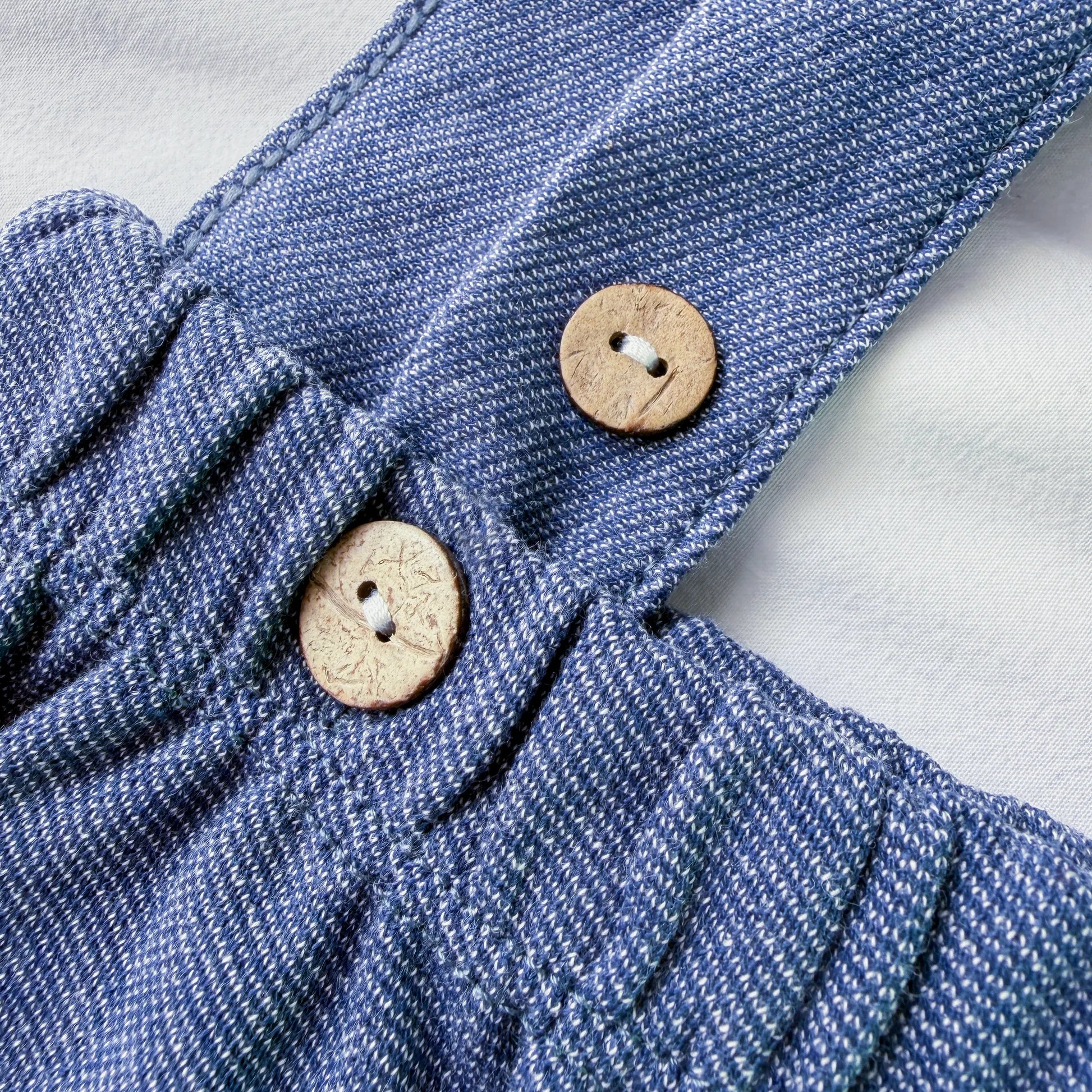 Detalle de pololo en tela efecto vaquero con botones de madera marino
