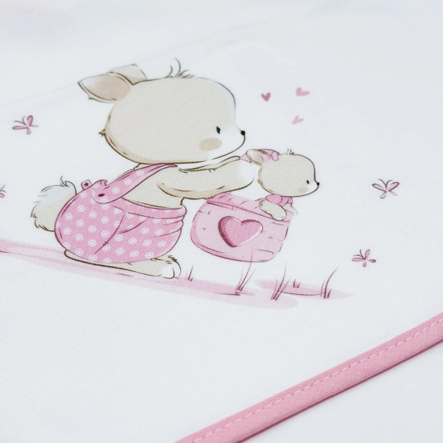 Detalle de paño para eructar con motivo de conejito en la cesta rosa