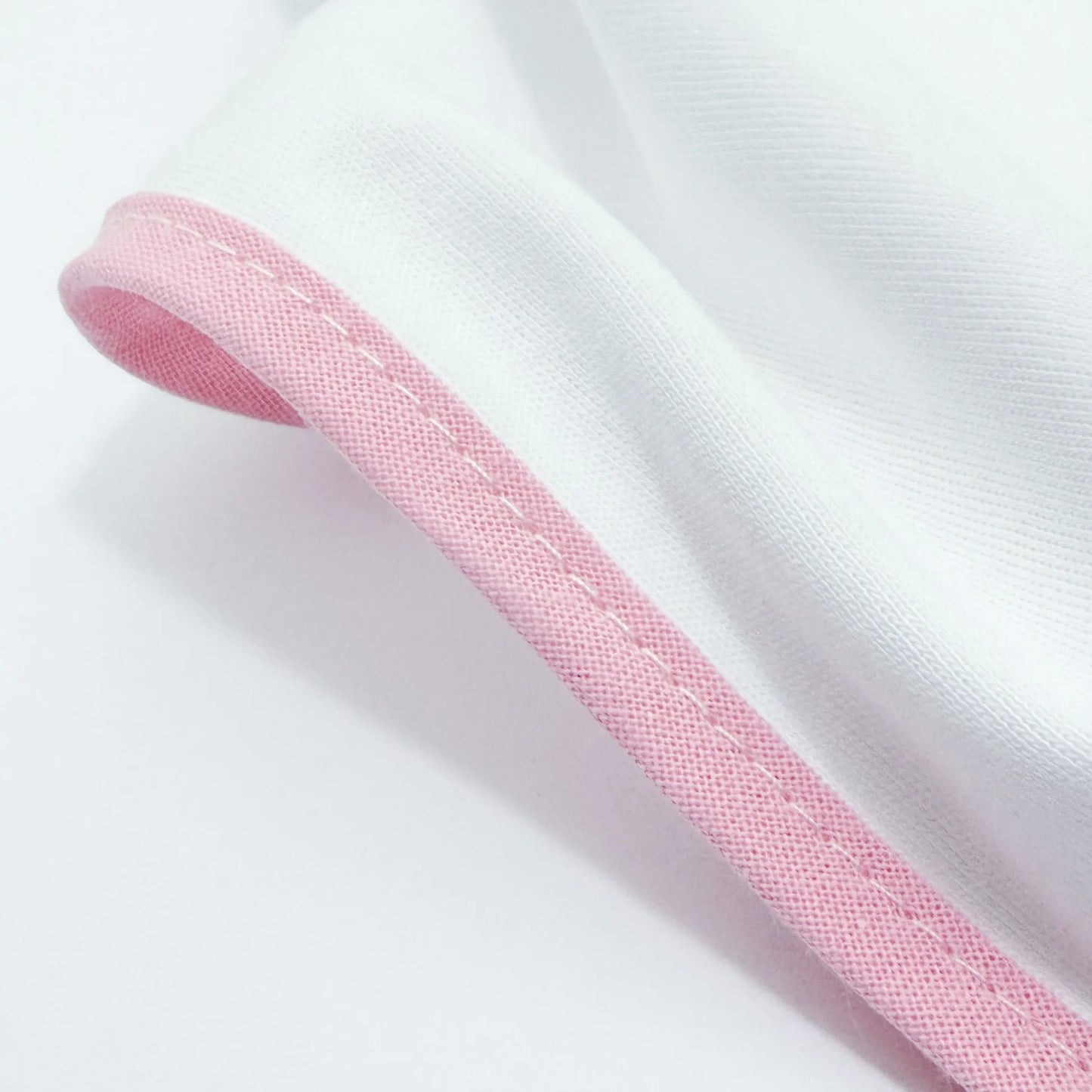 Detalle de paño para eructar con motivo de conejito en la cesta rosa