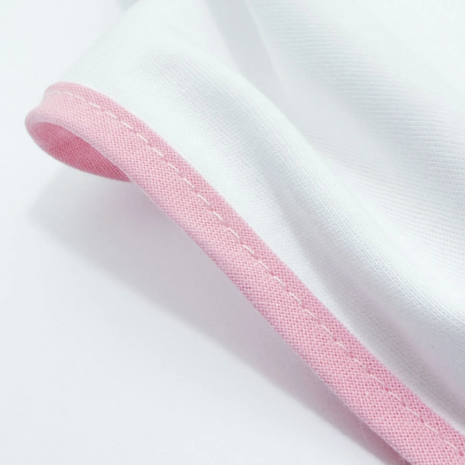 Detalle de paño para eructar con motivo de conejito en la cesta rosa