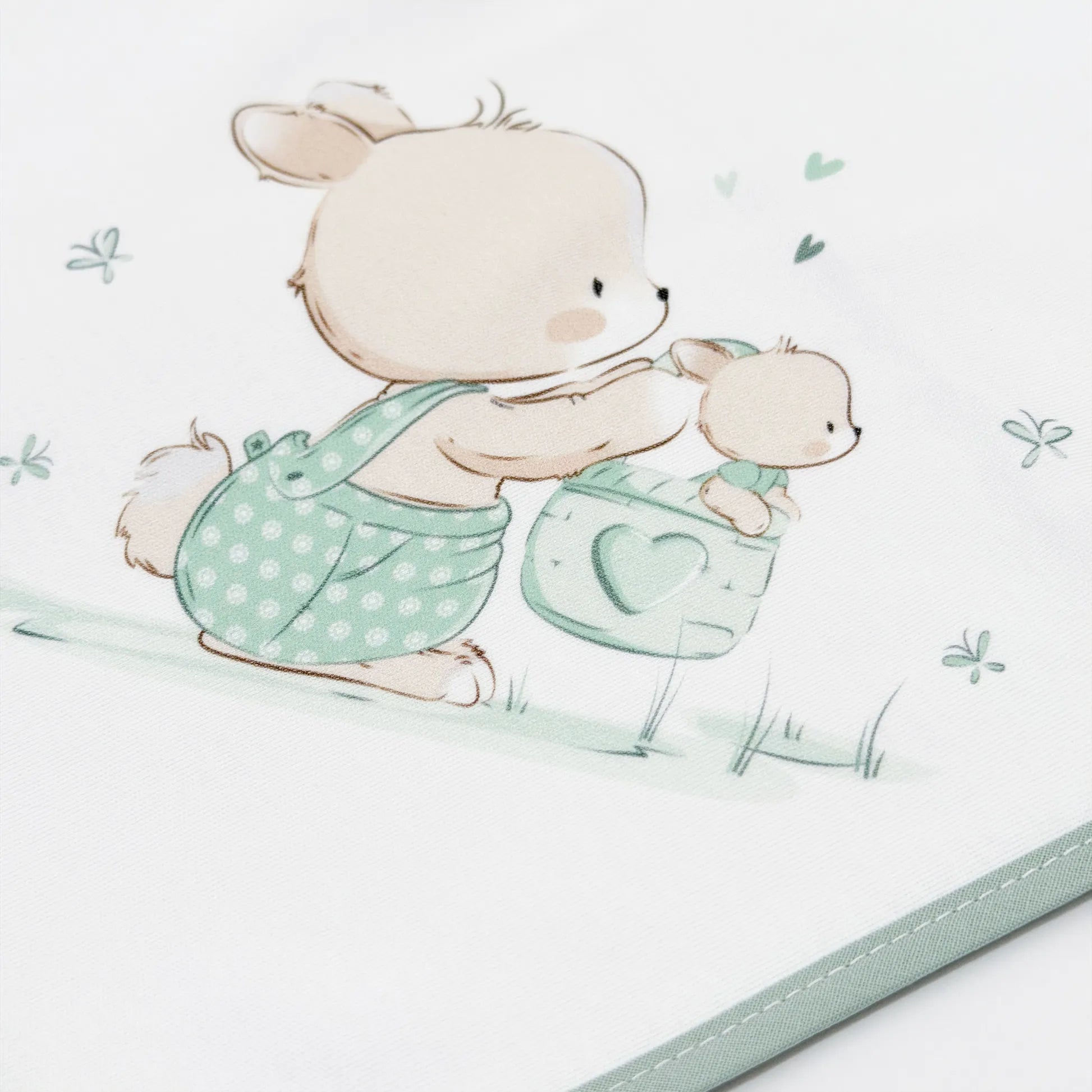 Detalle de paño para eructar con motivo de conejito en la cesta verde