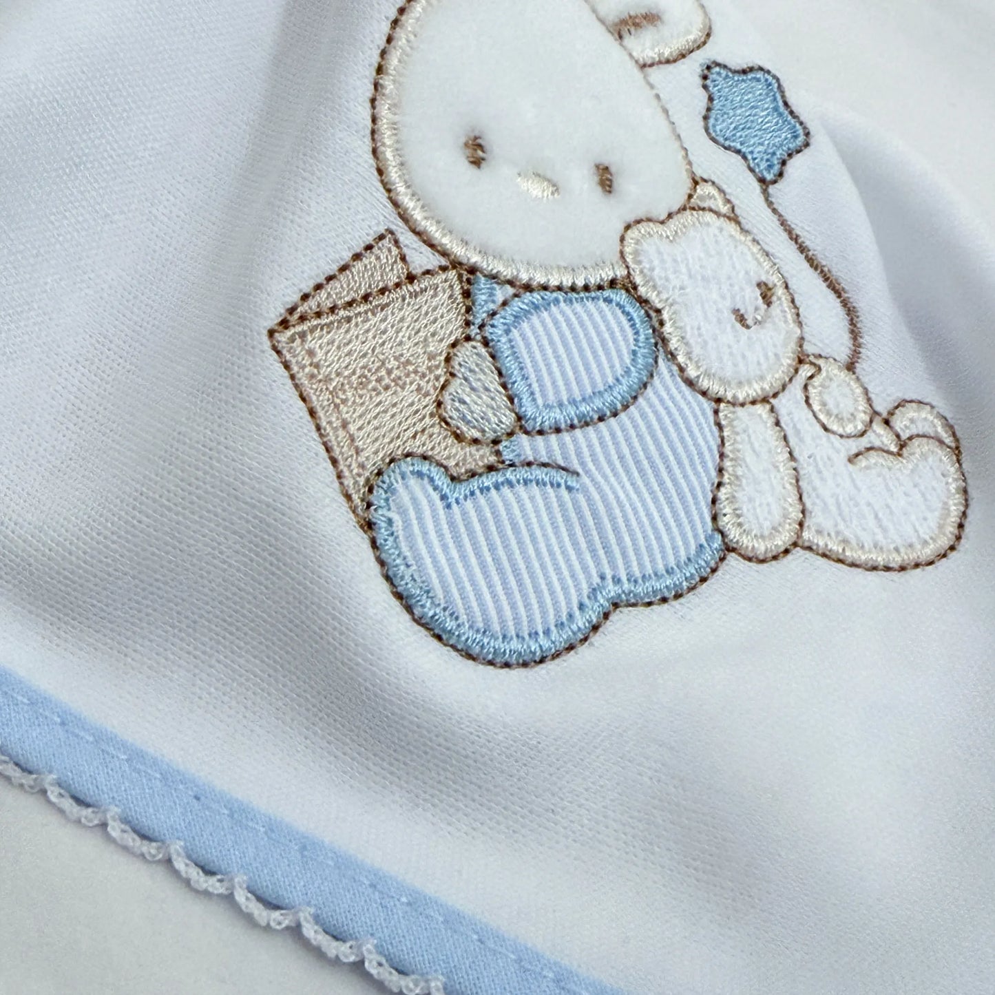 Detalle de paño para eructar con motivo de conejito y osito con libro azul
