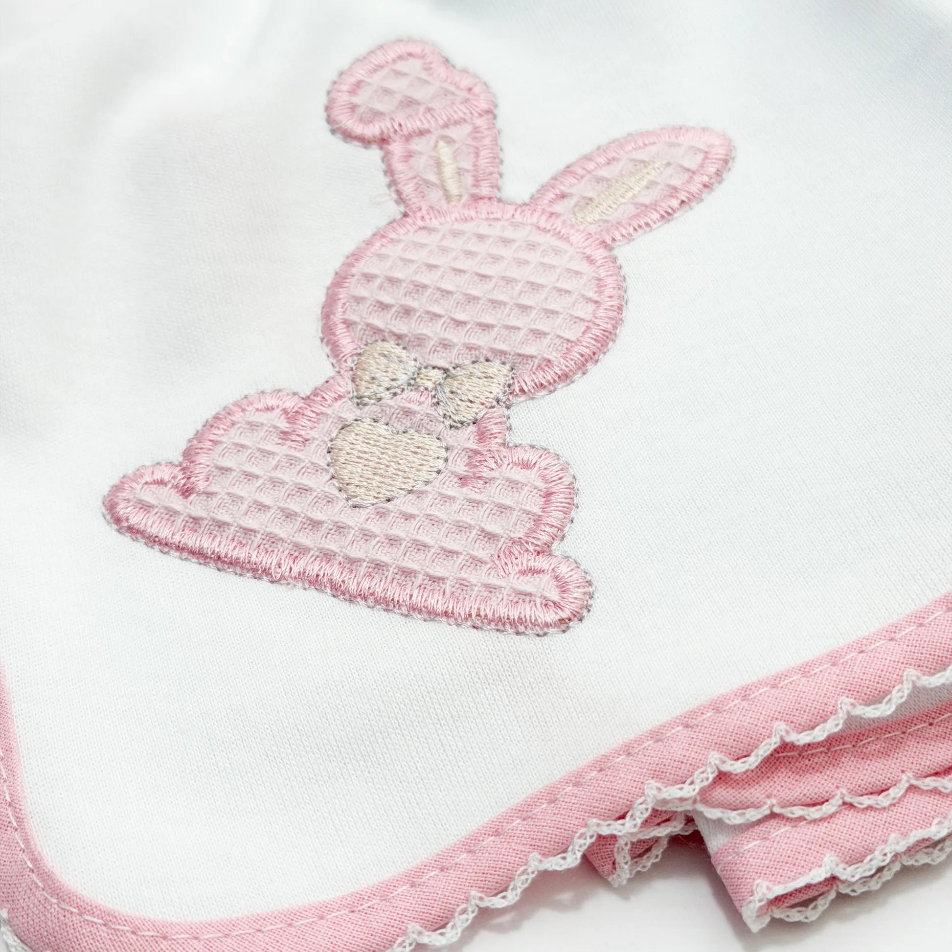 Detalle de paño para eructar con motivo de conejo waffle rosa