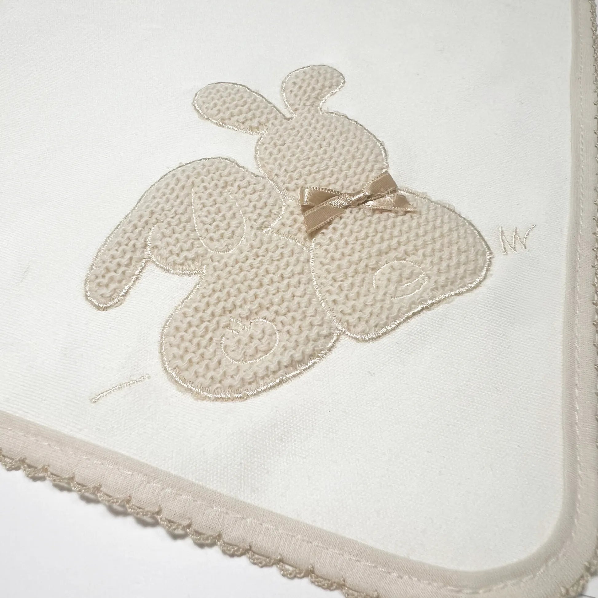 Detalle de paño para eructar con motivo de conejos de punto y lazito perla