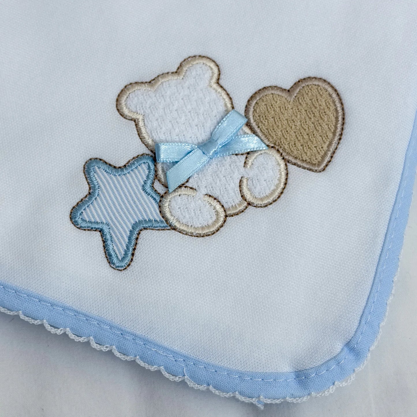 Detalle de paño para eructar con motivo de osito entre estrella y corazón azul