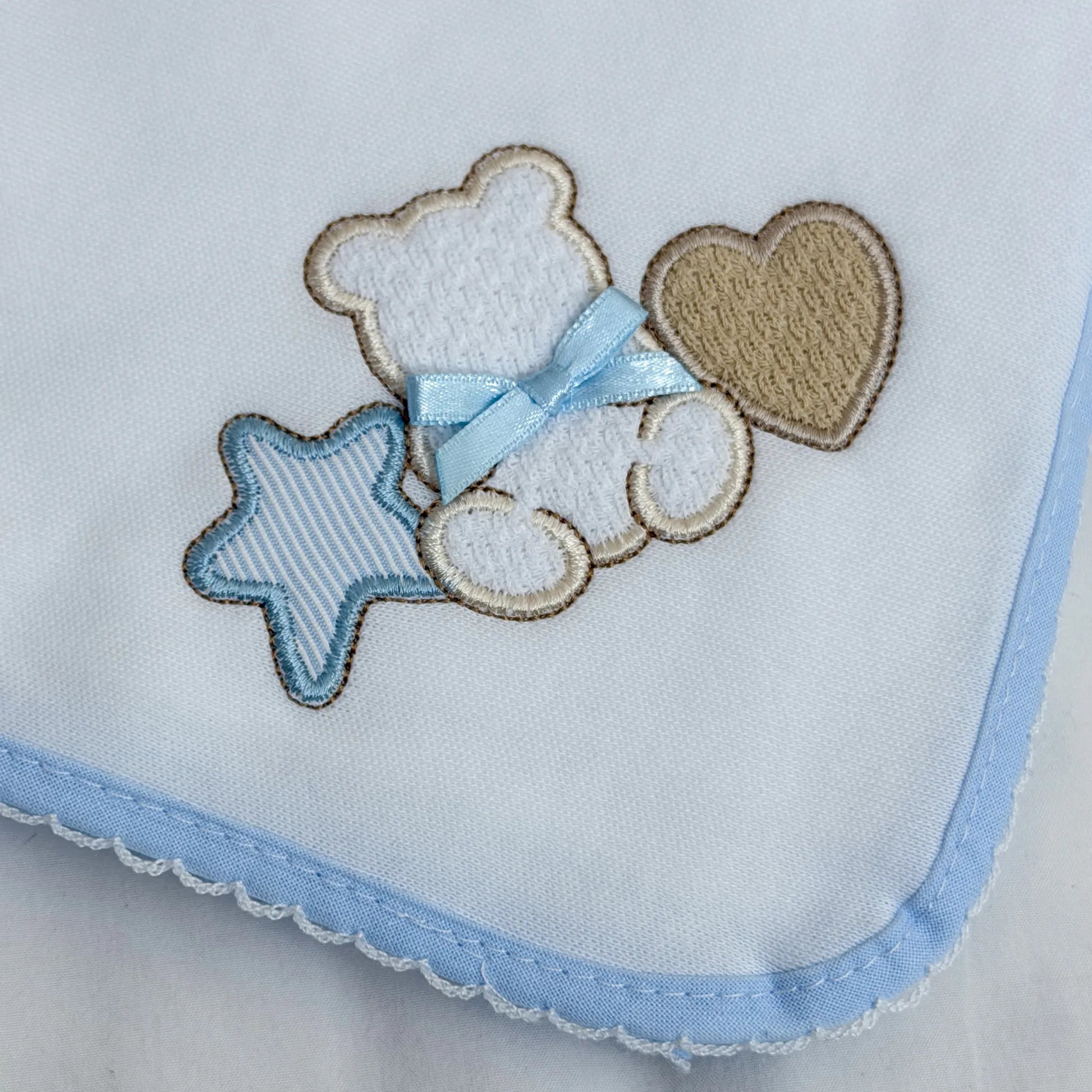 Detalle de paño para eructar con motivo de osito entre estrella y corazón azul