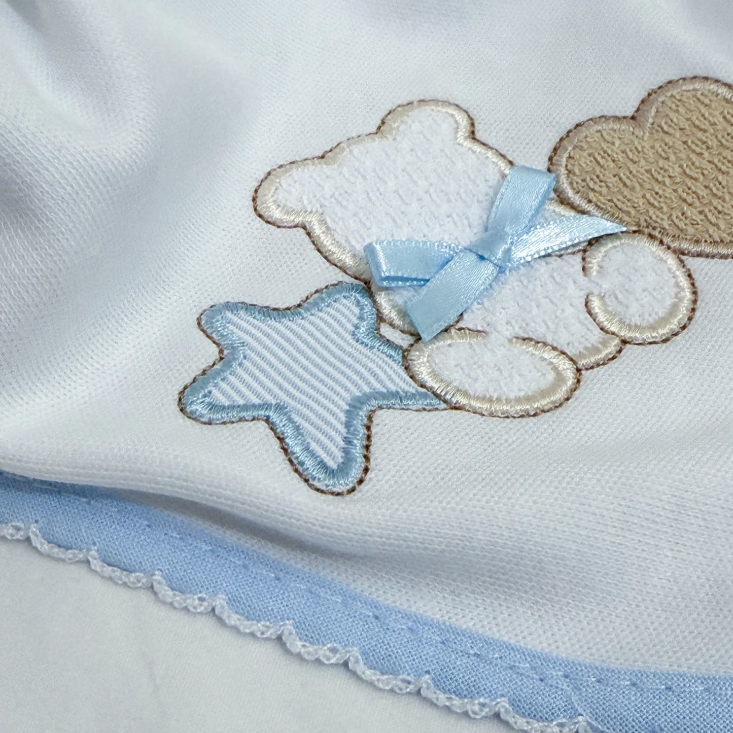 Detalle de paño para eructar con motivo de osito entre estrella y corazón azul