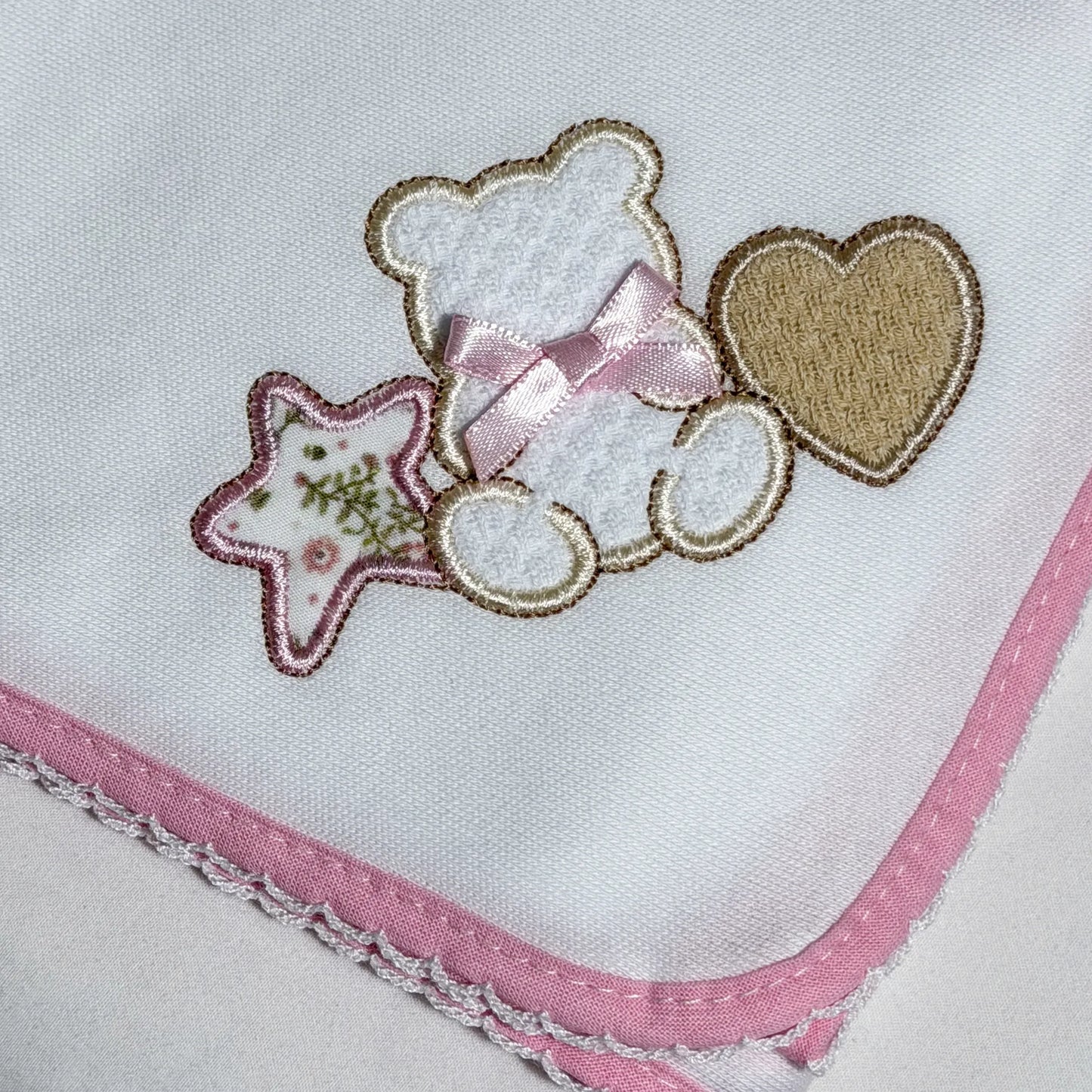 Detalle de paño para eructar con motivo de osito entre estrella y corazón rosa