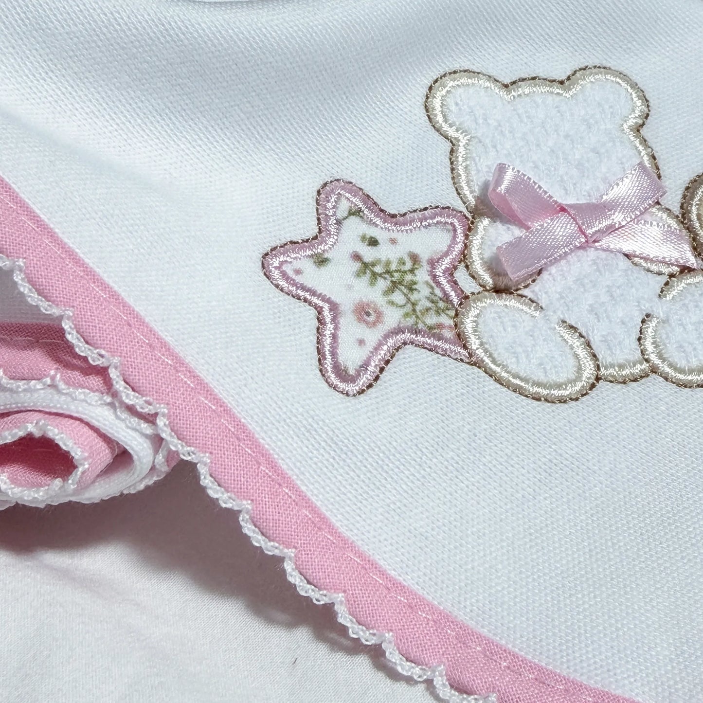 Detalle de paño para eructar con motivo de osito entre estrella y corazón rosa