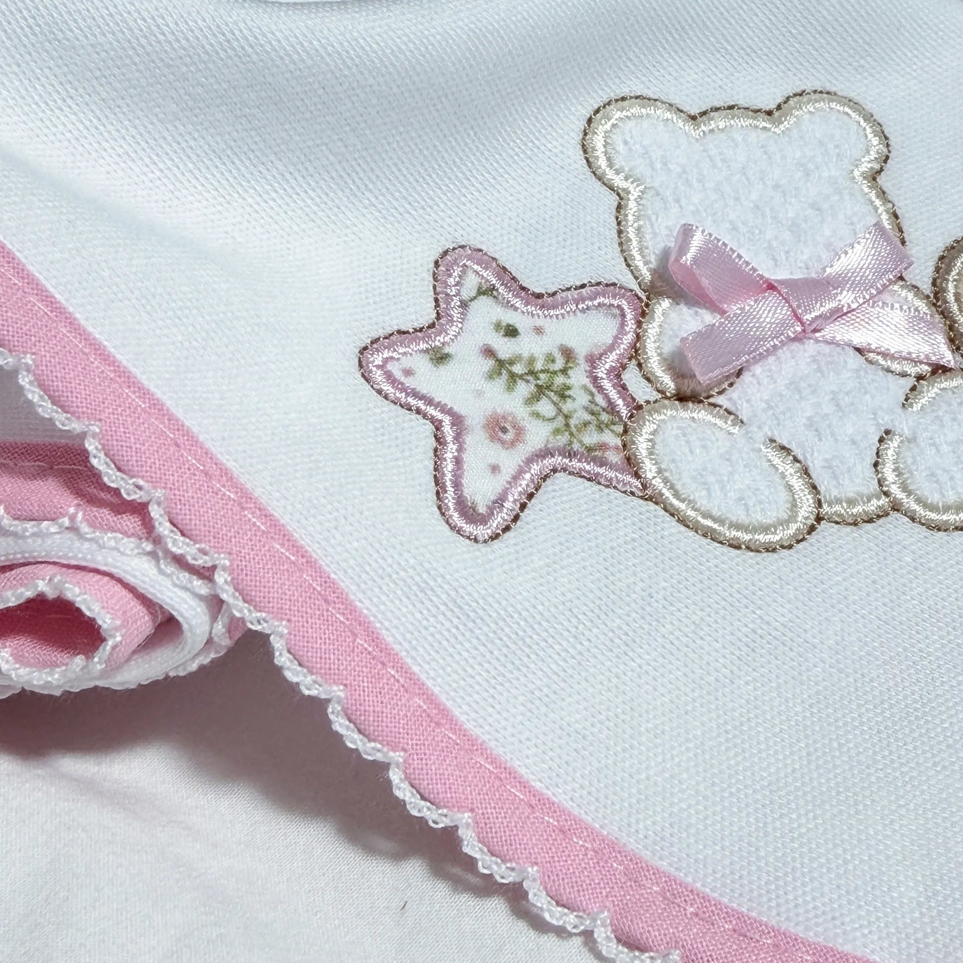 Detalle de paño para eructar con motivo de osito entre estrella y corazón rosa
