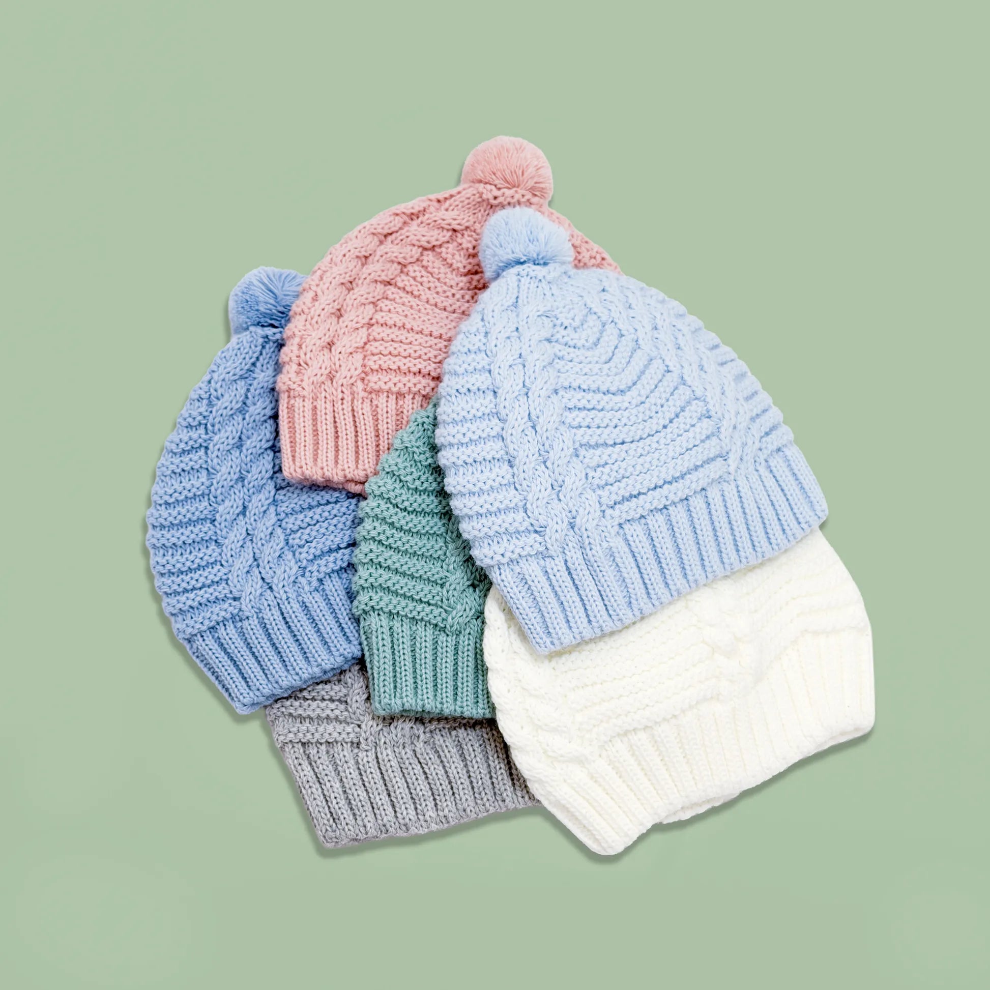 Gorros de punto trenzado con pompón en los colores gris, cobalto, azul, perla, rosa y verde