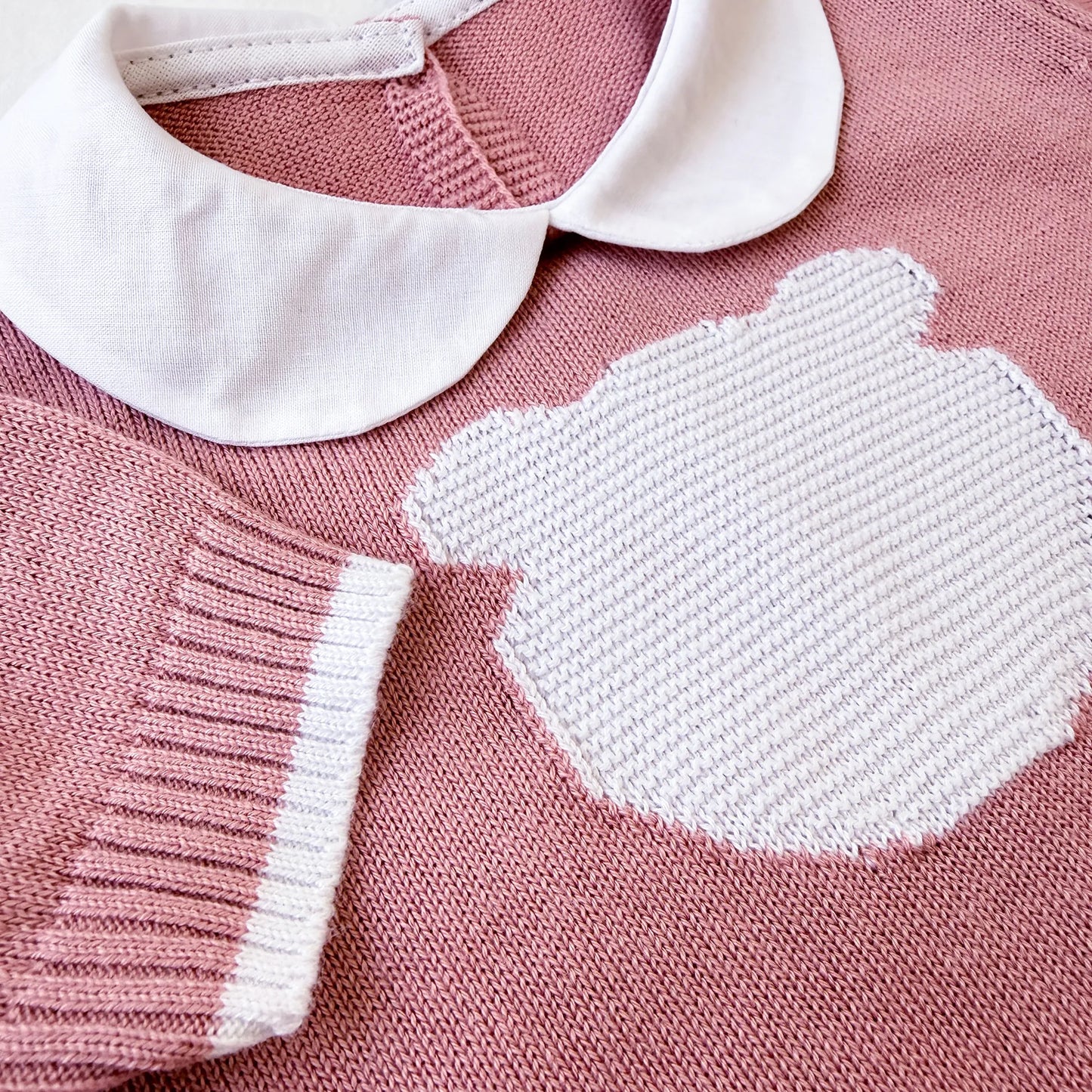 Detalle de mono de punto con cuello Peter Pan y motivo de osito rosa