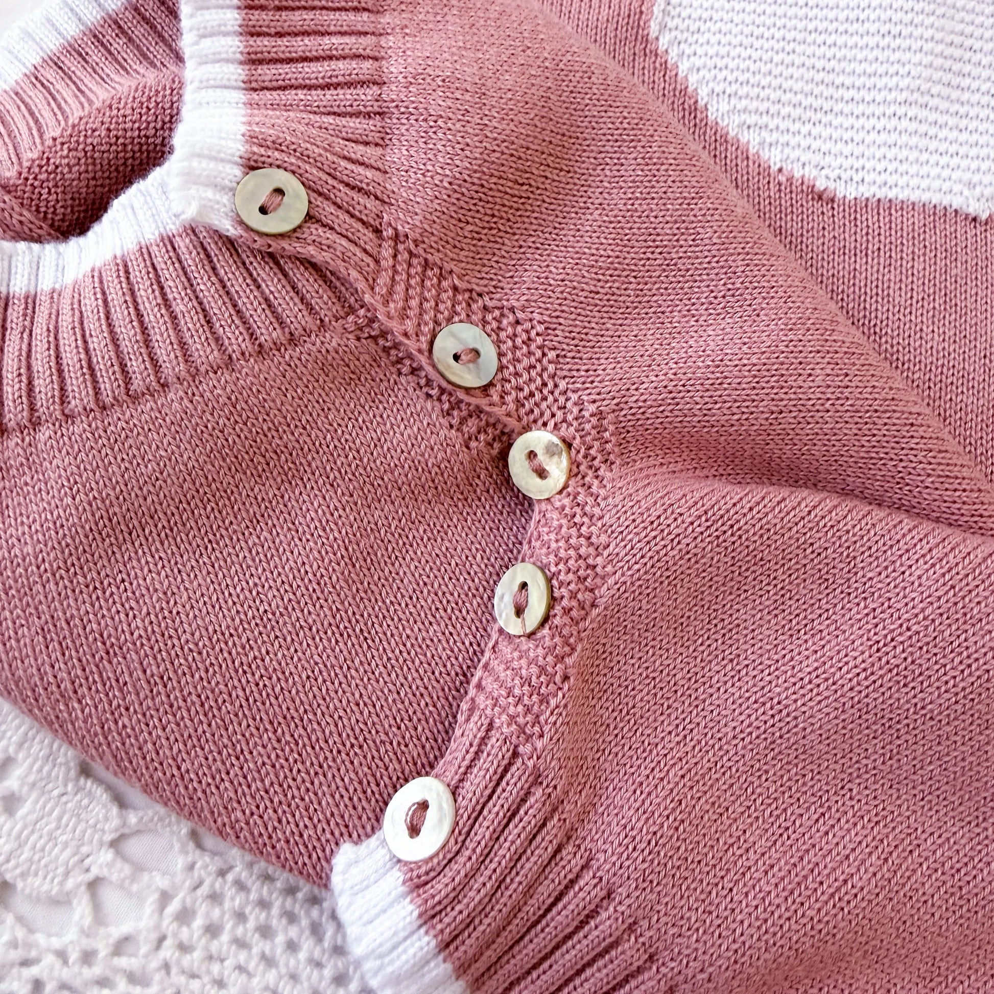 Detalle de mono de punto con cuello Peter Pan y motivo de osito rosa