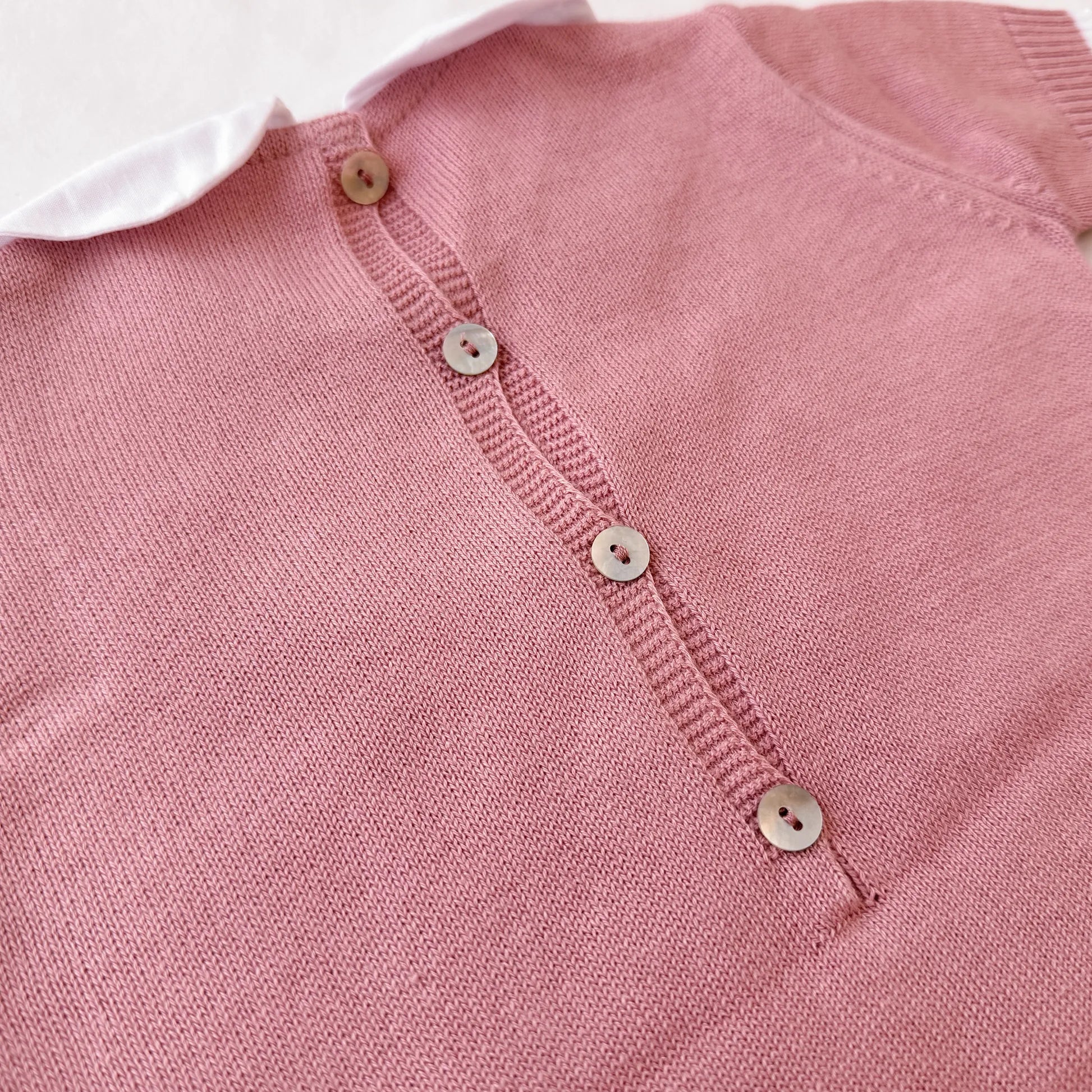 Detalle de mono de punto con cuello Peter Pan y motivo de osito rosa