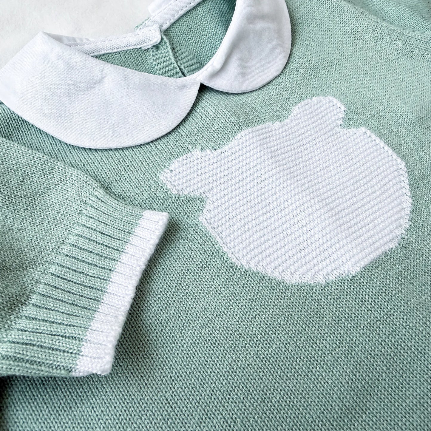 Detalle de mono de punto con cuello Peter Pan y motivo de osito verde