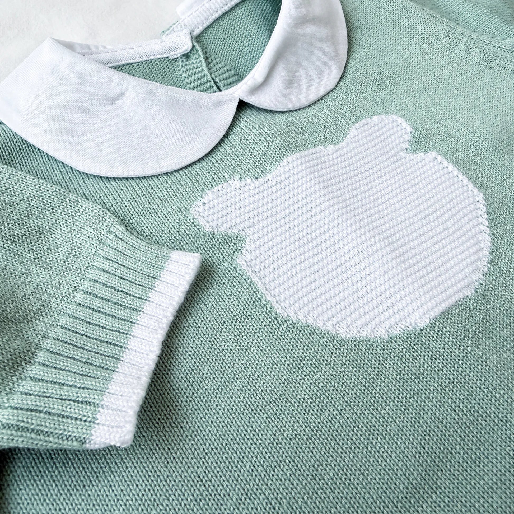 Detalle de mono de punto con cuello Peter Pan y motivo de osito verde