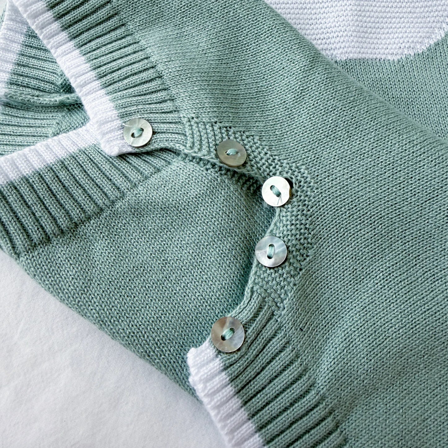 Detalle de mono de punto con cuello Peter Pan y motivo de osito verde