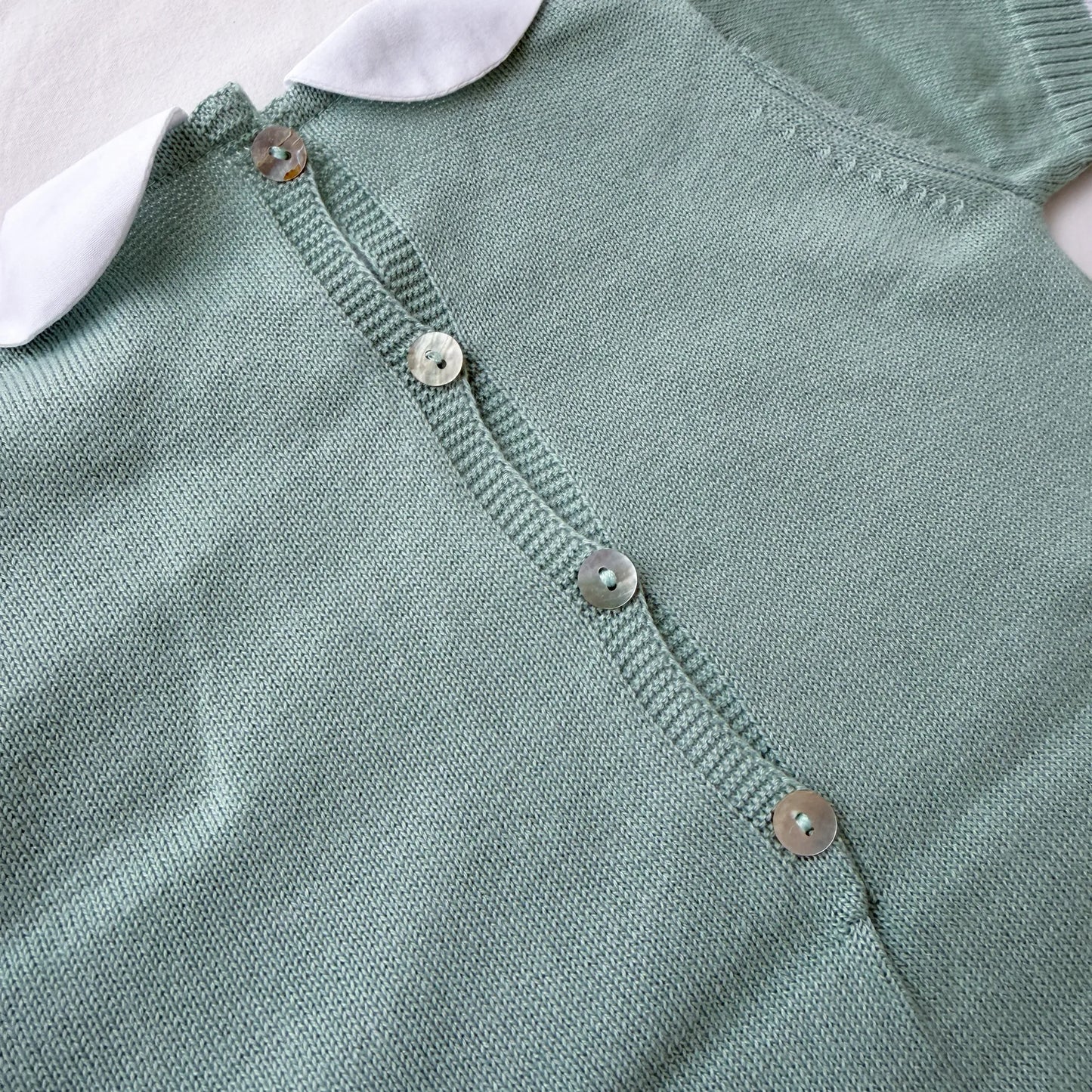 Detalle de mono de punto con cuello Peter Pan y motivo de osito verde