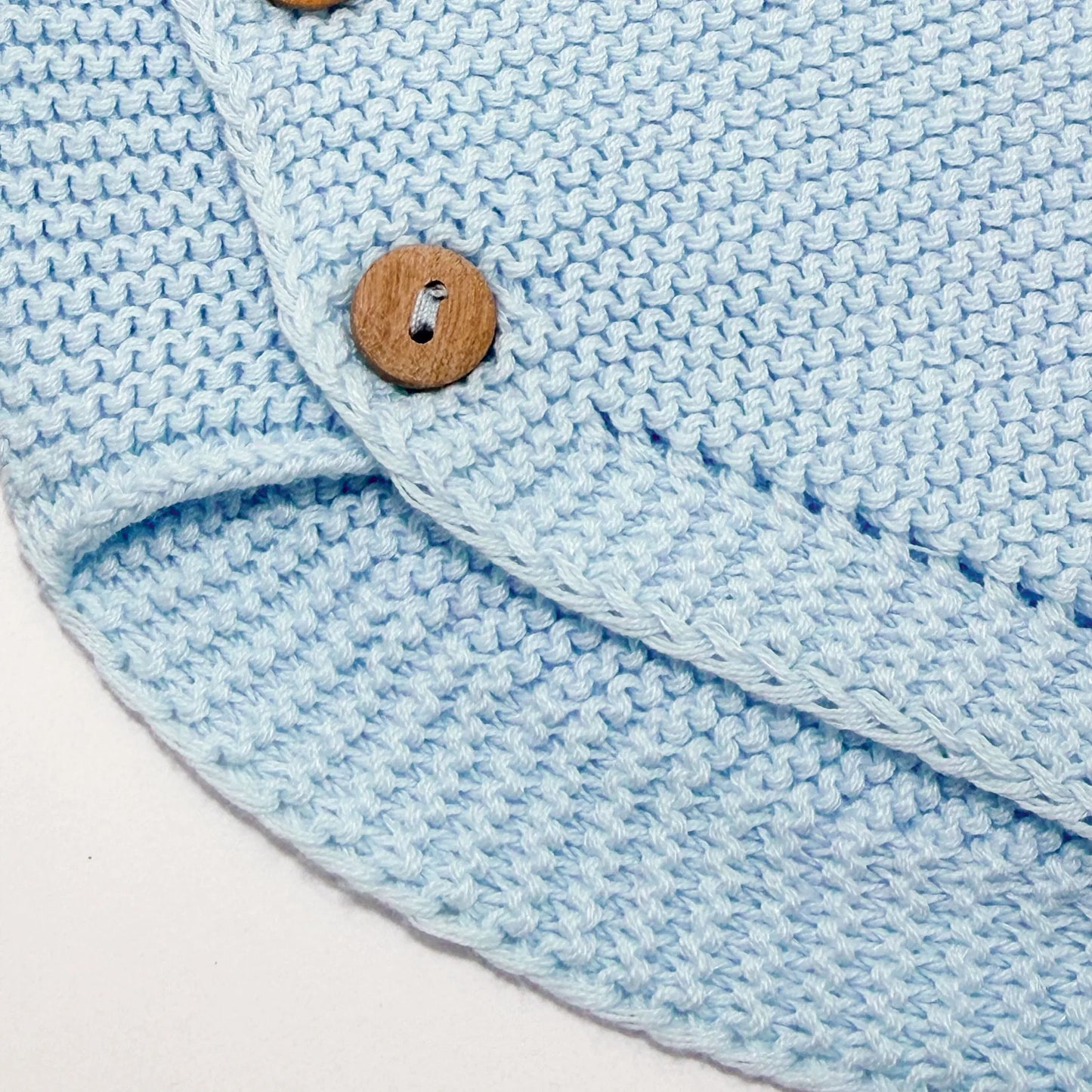 Detalle de cubrepañal de punto con botones de madera azul