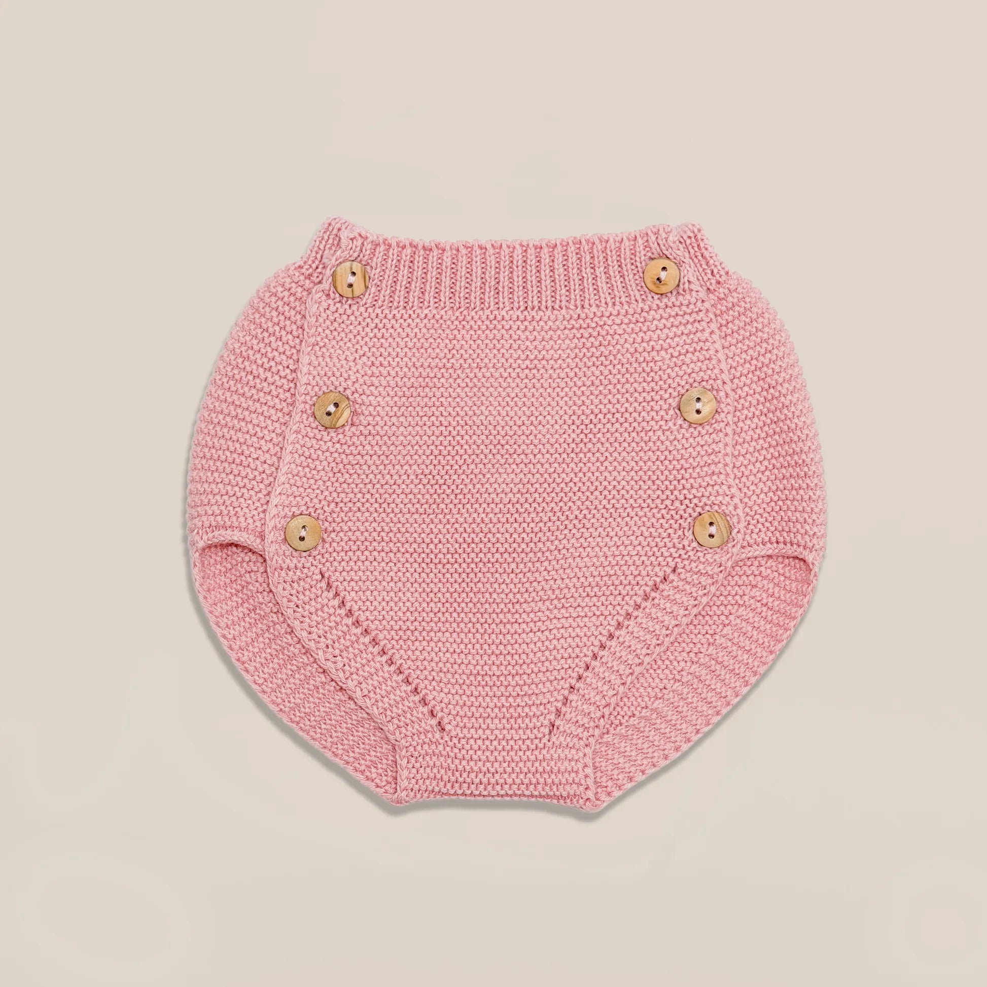 Cubrepañal de punto con botones de madera rosa
