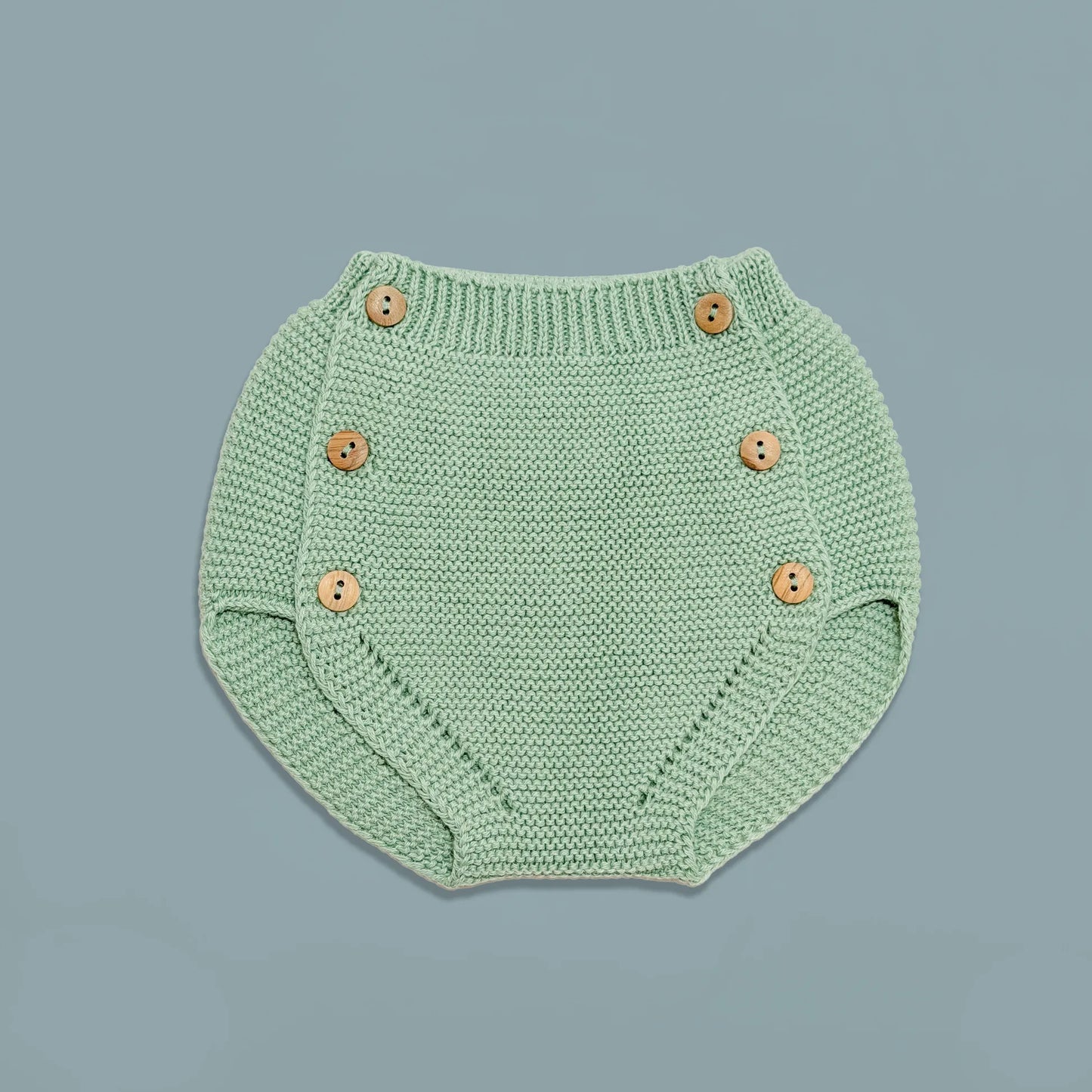 Cubrepañal de punto con botones de madera verde