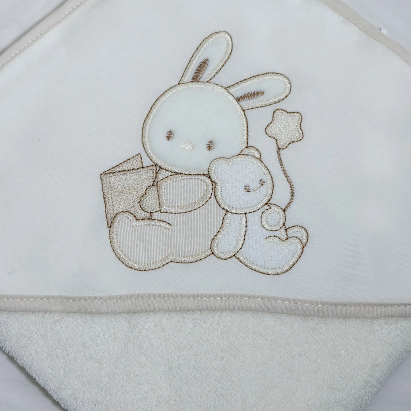 Detalle de toalla con motivo de conejito y osito con libro perla