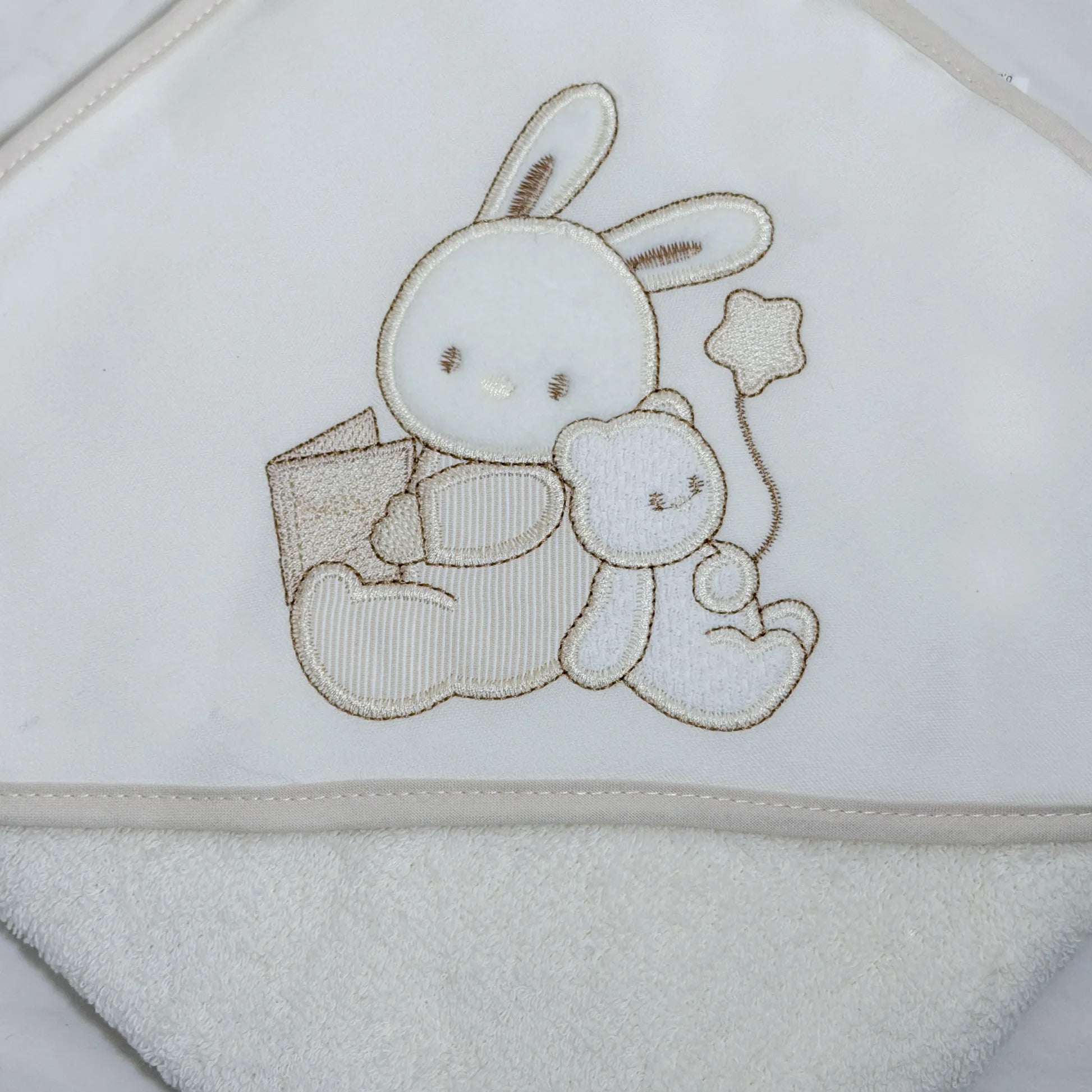 Detalle de toalla con motivo de conejito y osito con libro perla