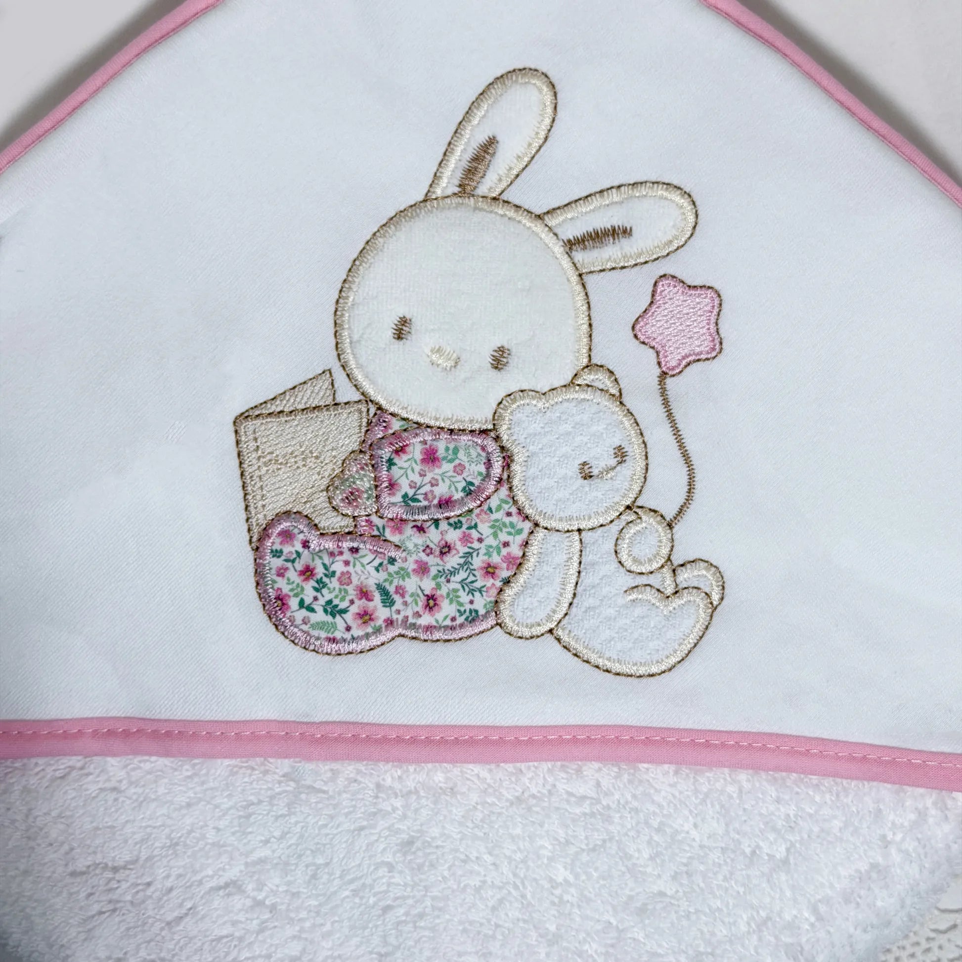 Detalle de toalla con motivo de conejito y osito con libro rosa