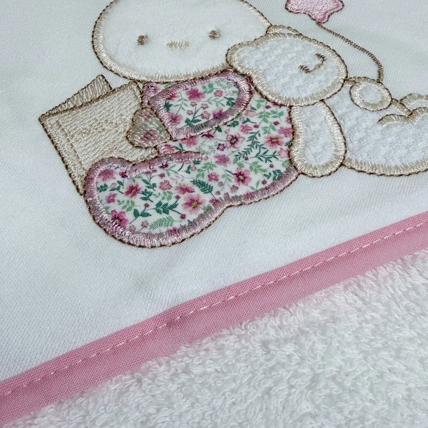 Detalle de toalla con motivo de conejito y osito con libro rosa