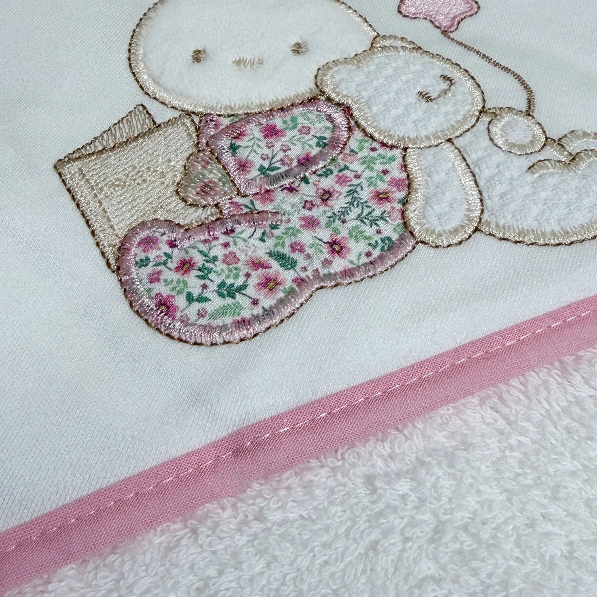 Detalle de toalla con motivo de conejito y osito con libro rosa