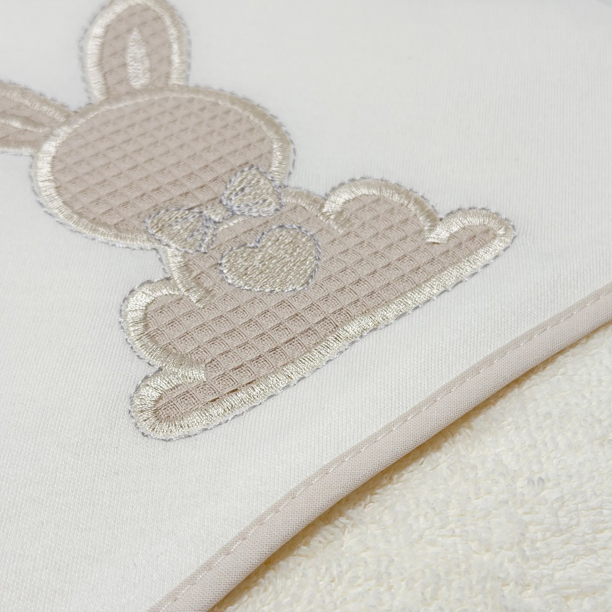 Detalle de toalla con motivo de conejo waffle perla