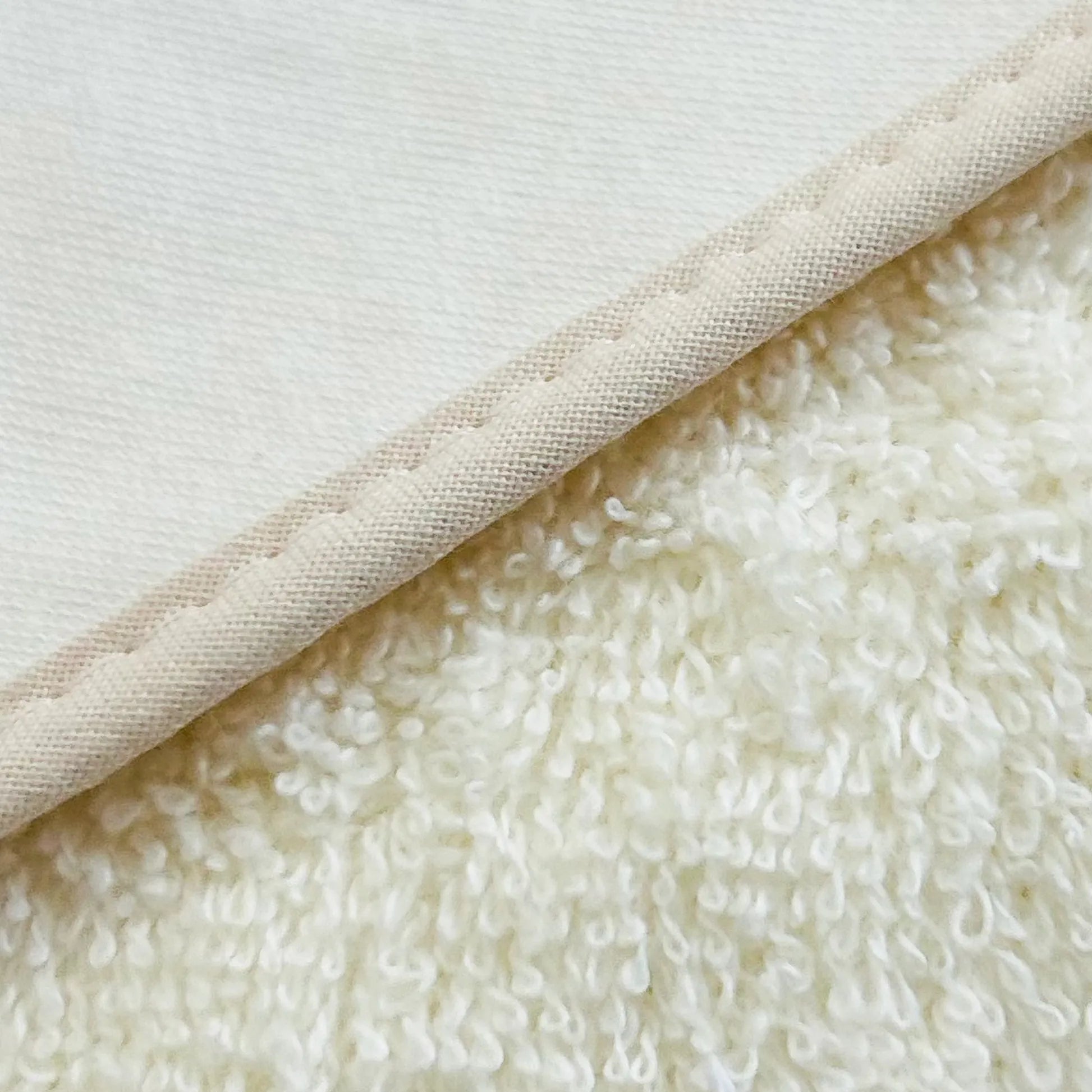 Detalle de toalla con motivo de conejos de punto y lazo perla