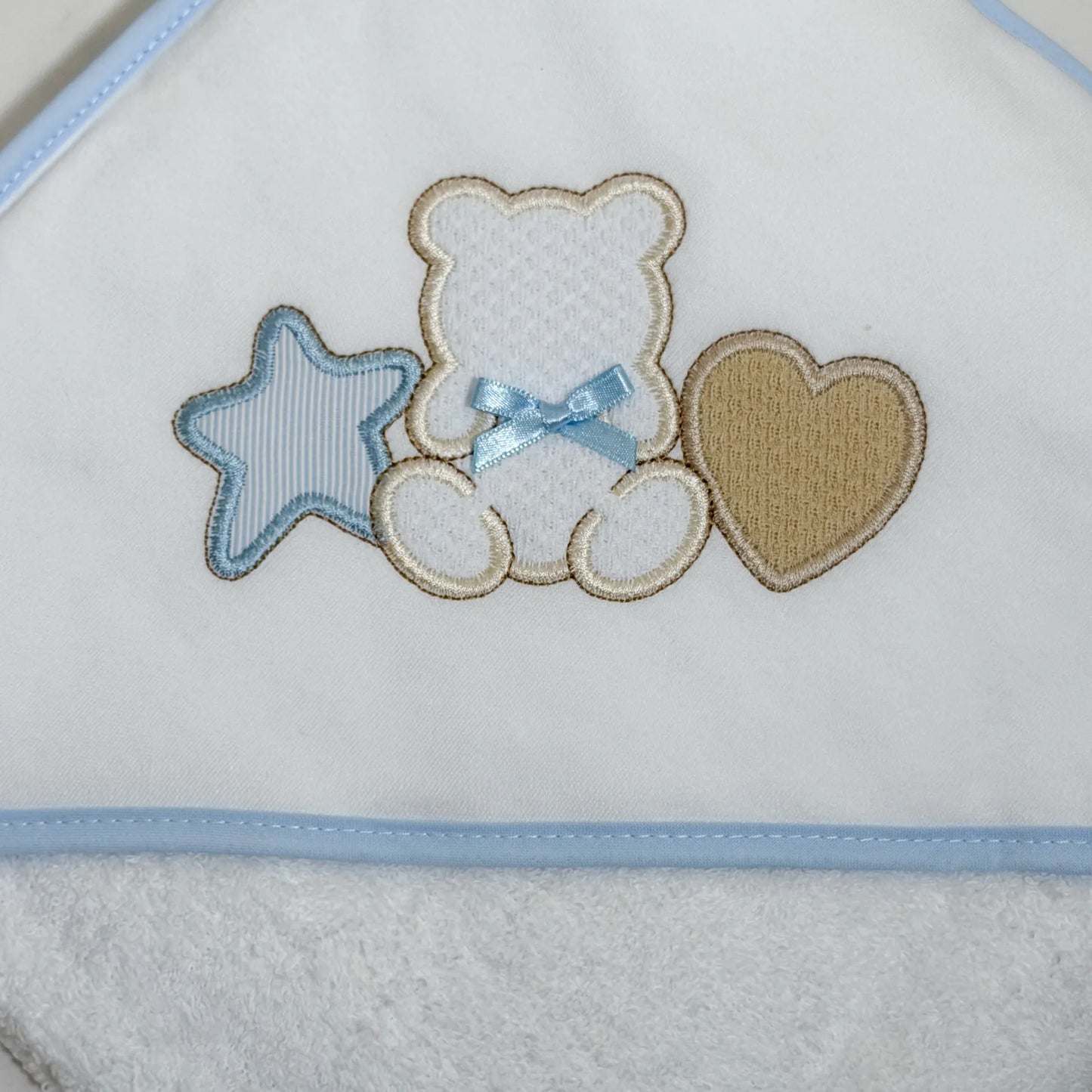 Detalle de toalla con motivo de osito entre estrella y corazón azul