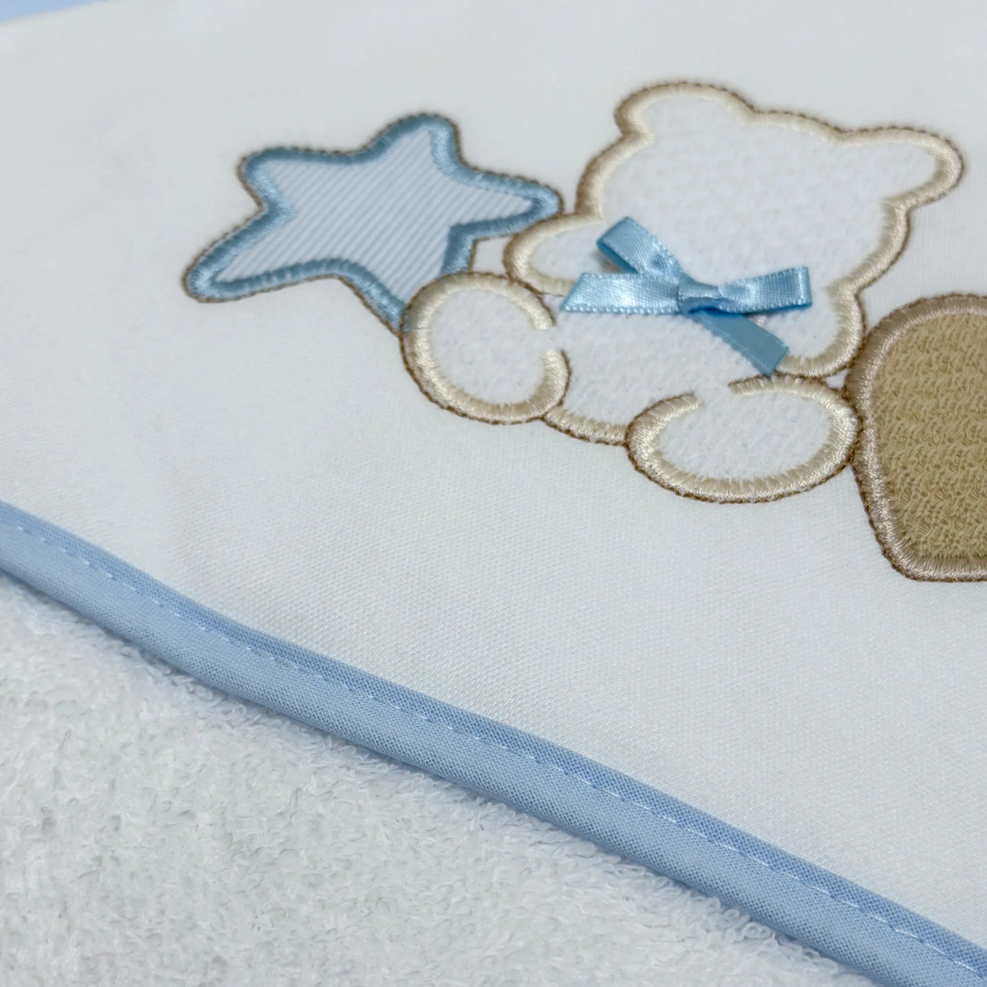 Detalle de toalla con motivo de osito entre estrella y corazón azul