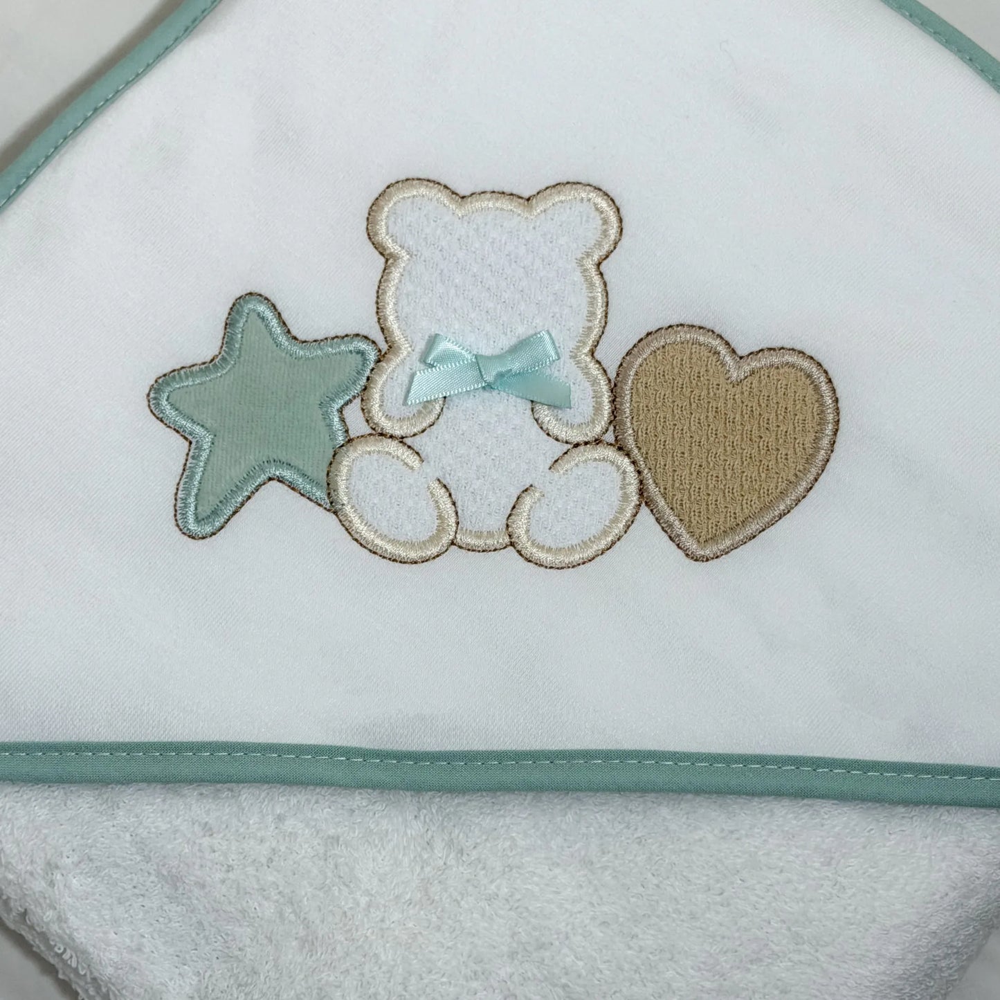 Detalle de toalla con motivo de osito entre estrella y corazón verde