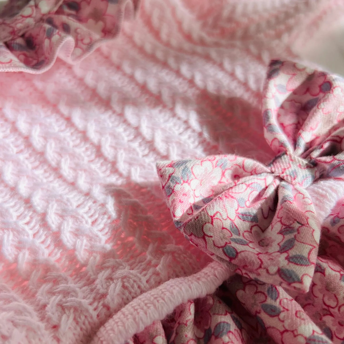 Detalle de vestido estampado con volante en el cuello y lazo en la cintura rosa