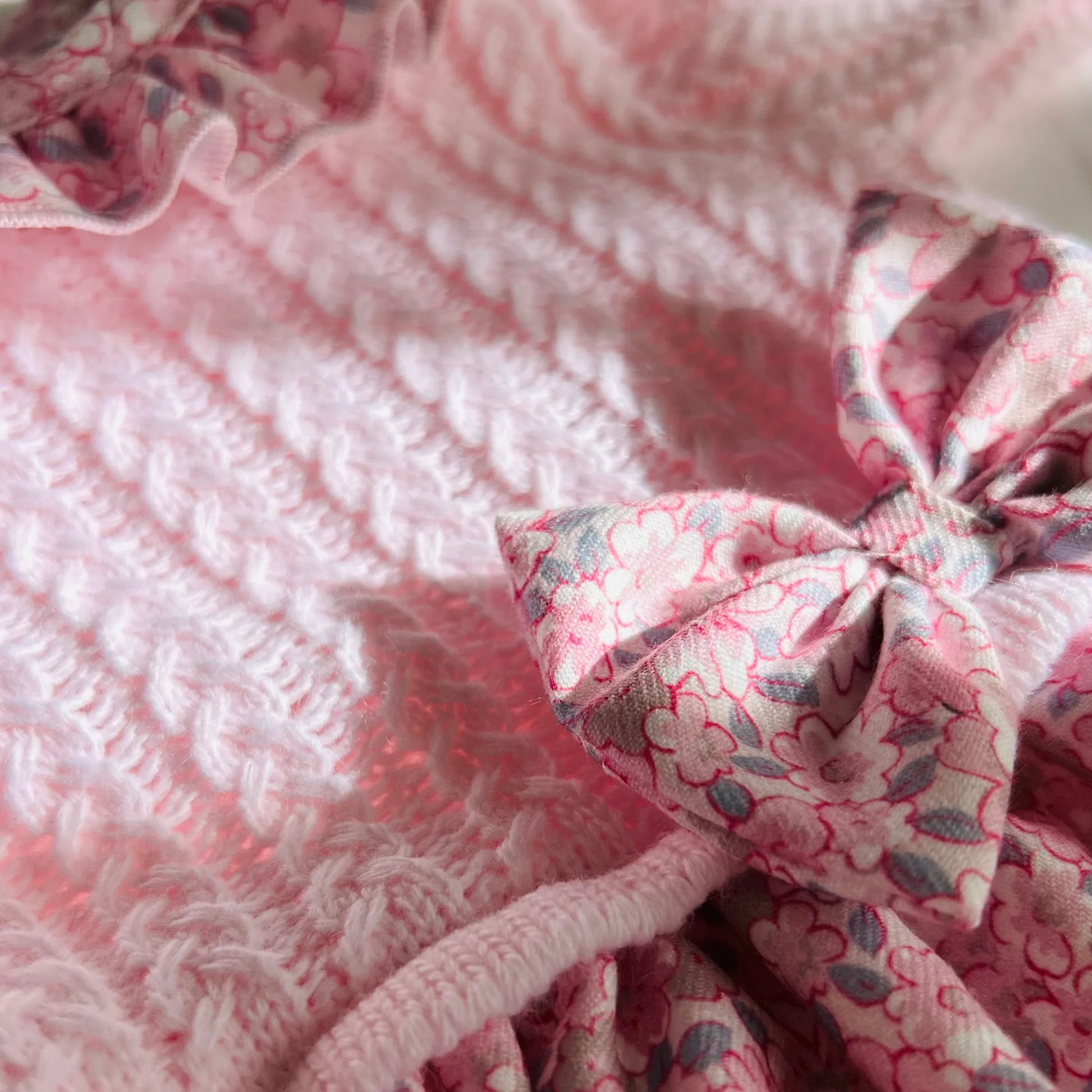 Detalle de vestido estampado con volante en el cuello y lazo en la cintura rosa